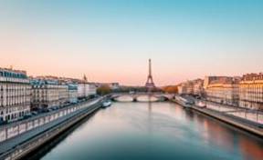Amanecer sereno sobre el río Sena y el icónico París histórico.