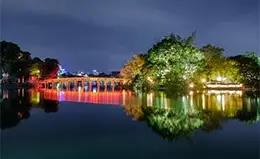 Pasea por el lago Hoan Kiem y cruza el puente rojo The Huc.